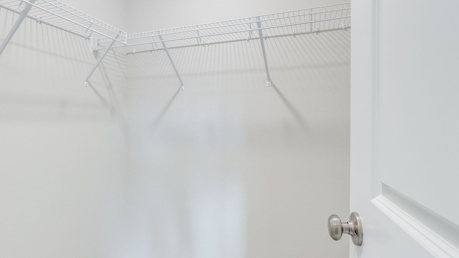 Primary bedroom walk-in closet with wire shelves