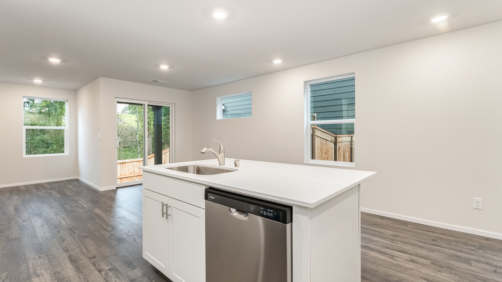 Kitchen with shaker cabinets, quartz counters, stainless steel appliances, pantry, and an island with a breakfast bar