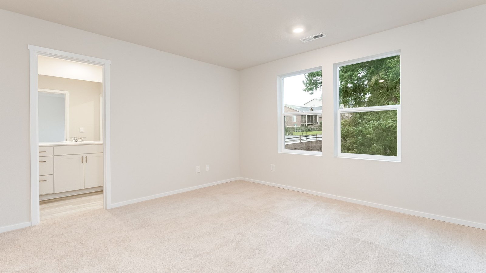 Primary bedroom with wall-to-wall carpet, a walk-in closet and an attached bathroom