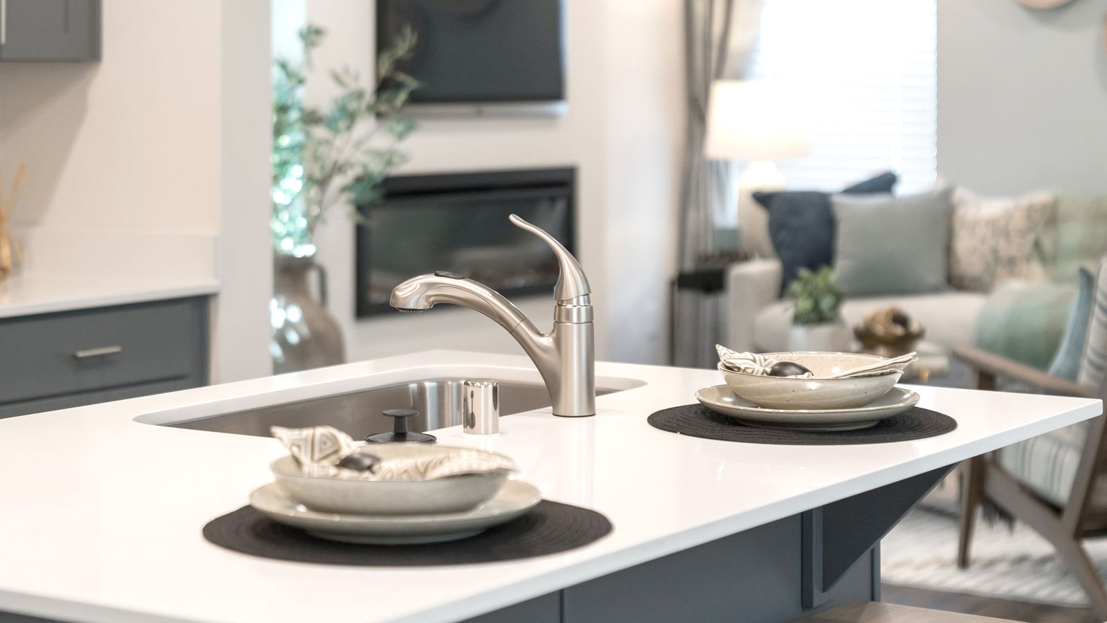 Kitchen with shaker cabinets, quartz counters, stainless steel appliances, pantry, and an island with a breakfast bar