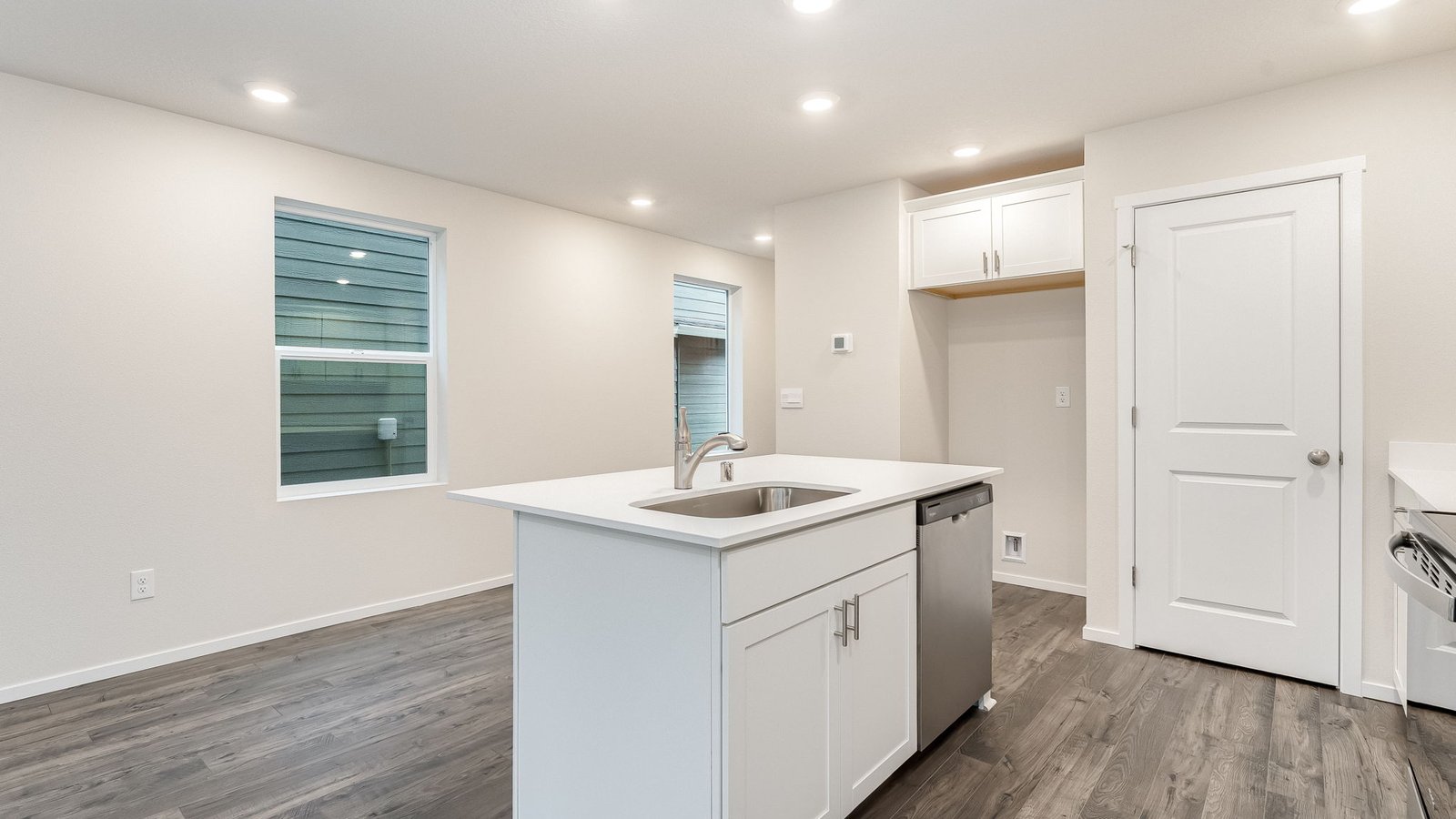 Kitchen with shaker cabinets, quartz counters, stainless steel appliances, pantry, and an island with a breakfast bar