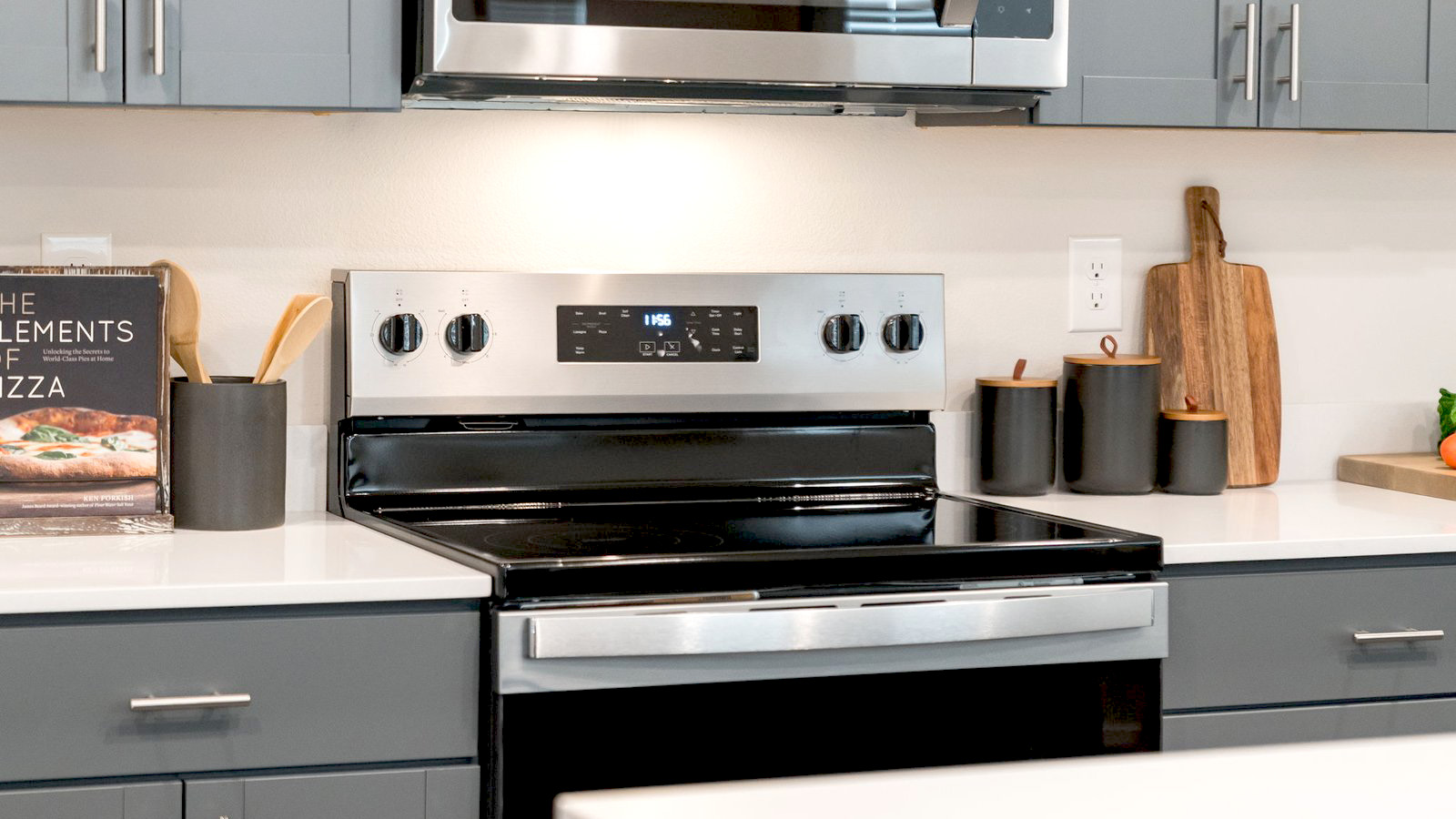Kitchen with shaker cabinets, quartz counters, stainless steel appliances, pantry, and an island with a breakfast bar