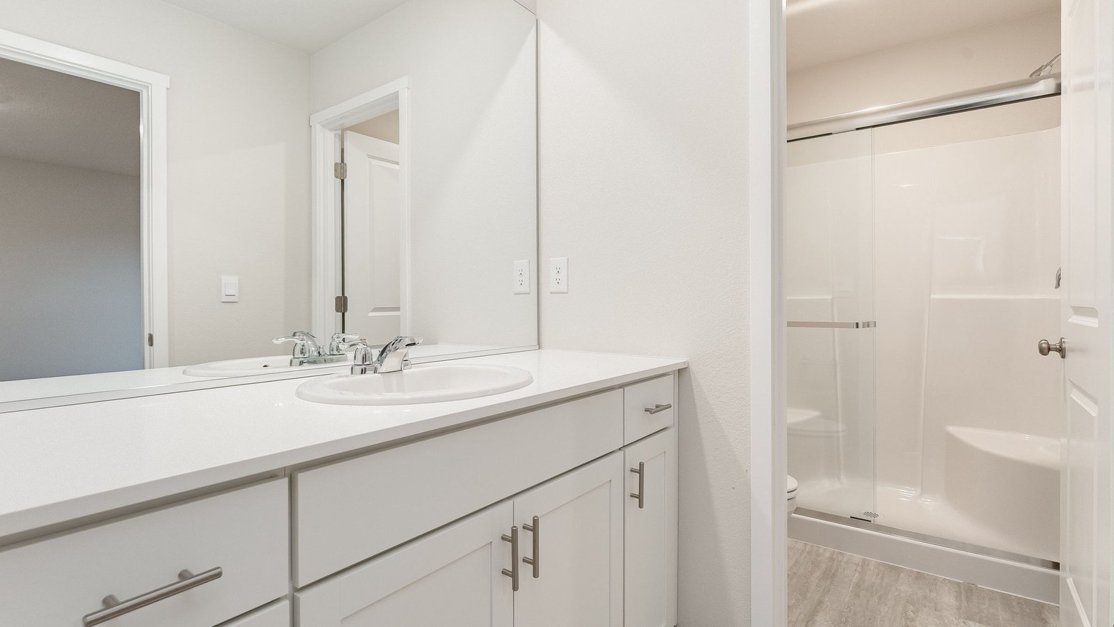 Primary bathroom with quartz counters and a walk-in shower