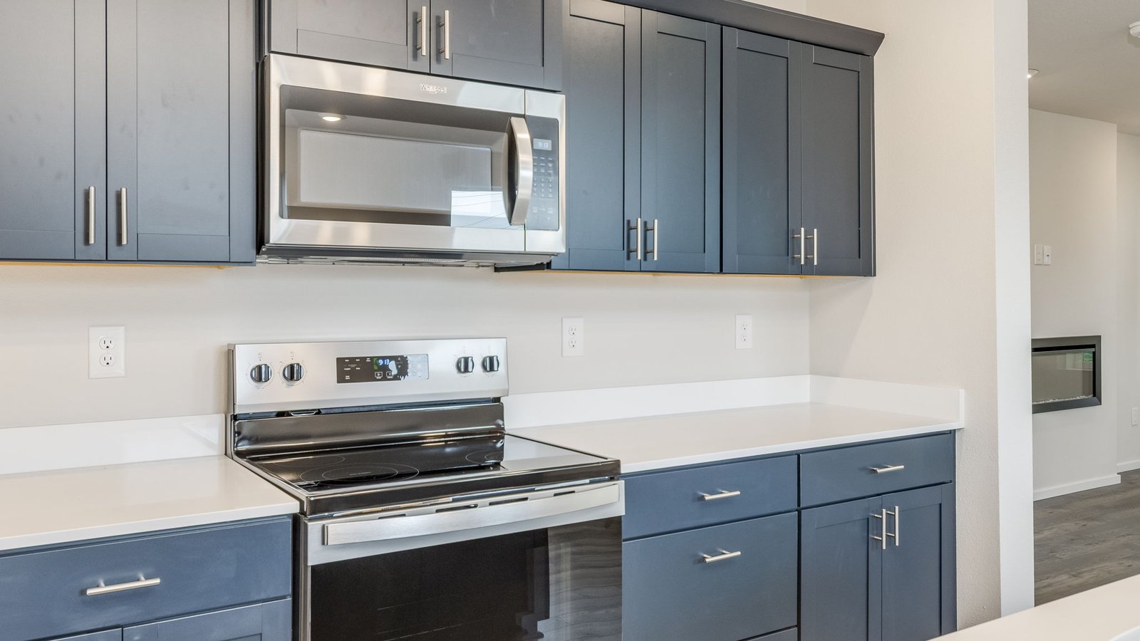 Kitchen with shaker cabinets, quartz counters, stainless steel appliances, pantry, and an island with a breakfast bar