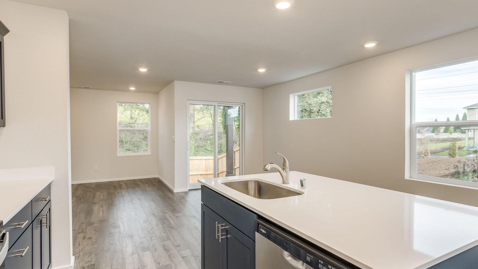 Kitchen with shaker cabinets, quartz counters, stainless steel appliances, pantry, and an island with a breakfast bar