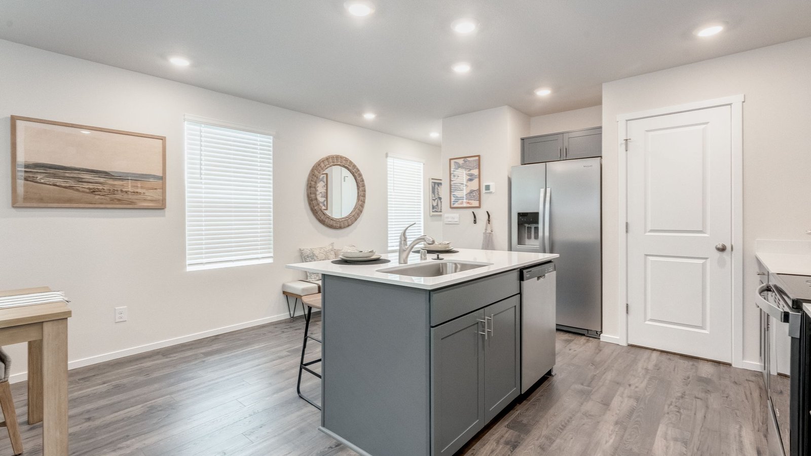 Kitchen with shaker cabinets, quartz counters, stainless steel appliances, pantry, and an island with a breakfast bar