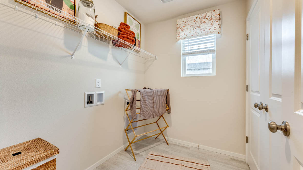 Laundry room with built-in shelves and washer and dryer hookups