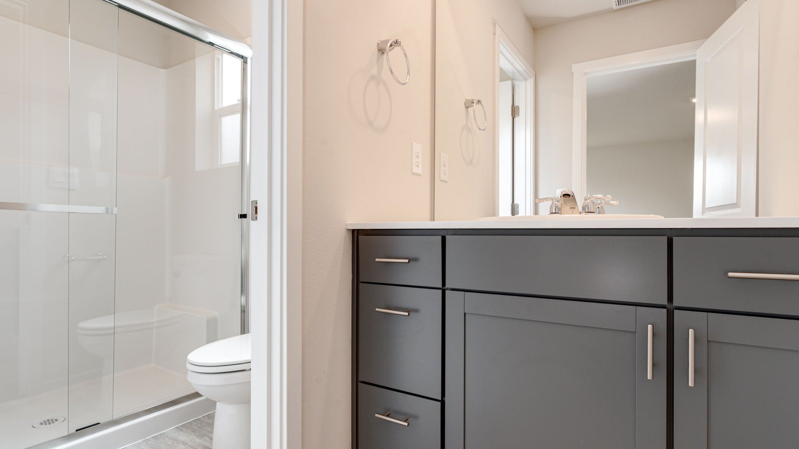 Primary bathroom with quartz counters and a walk-in shower