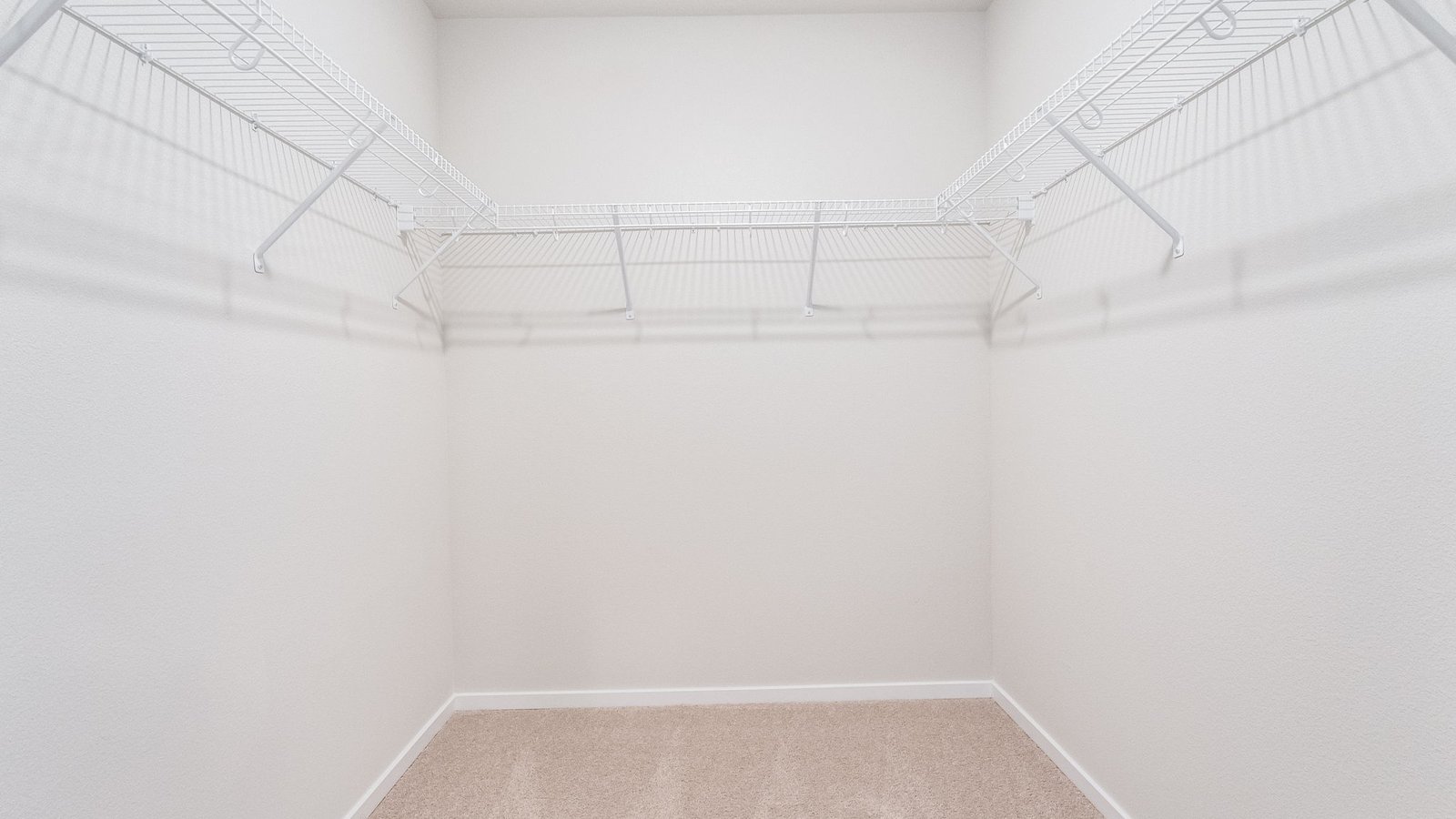 Primary bedroom walk-in closet with wire shelves