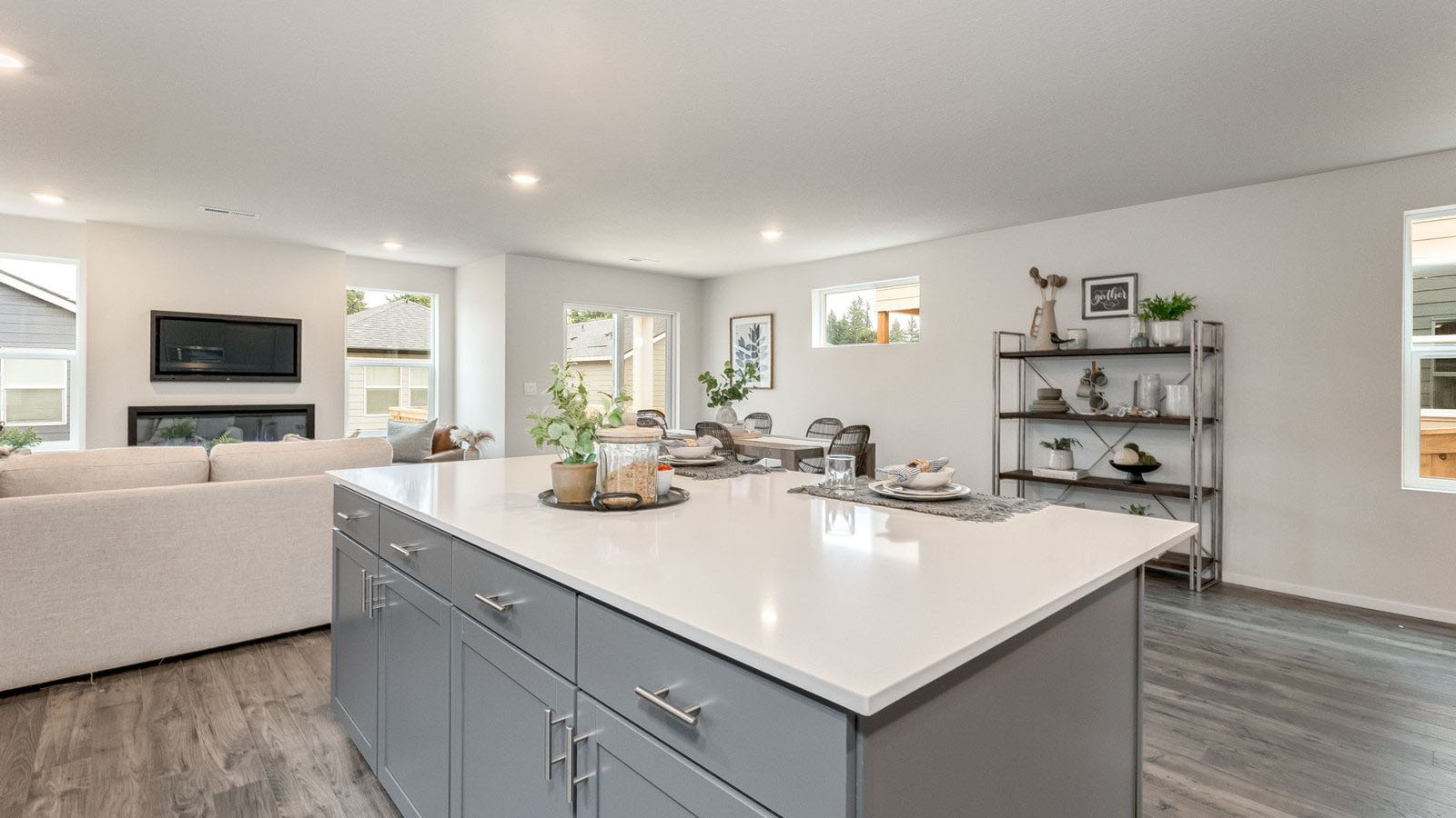 Kitchen with shaker cabinets, quartz counters, stainless steel appliances, pantry, and an island with a breakfast bar