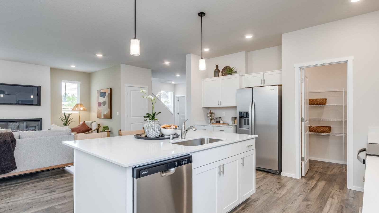 Kitchen with shaker cabinets, quartz counters, stainless steel appliances, pantry, and an island with a breakfast bar