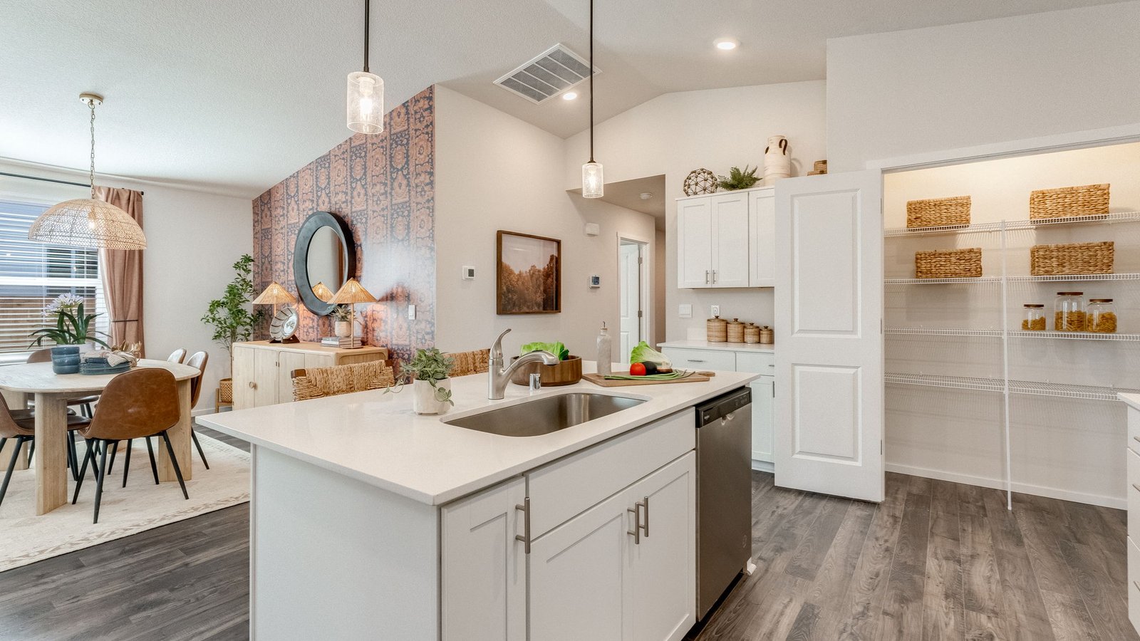 Kitchen with shaker cabinets, quartz counters, stainless steel appliances, pantry, and an island with a breakfast bar