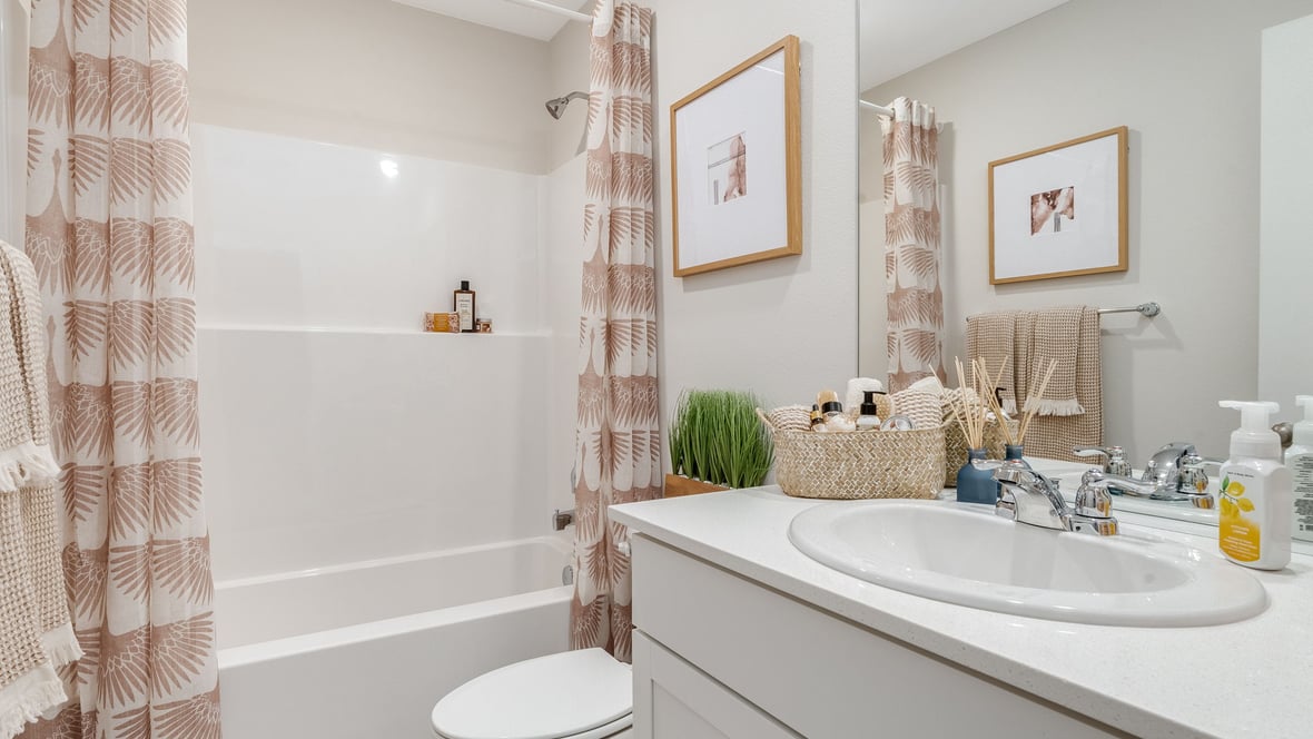 Hall bathroom with combination tub/shower and quartz counters