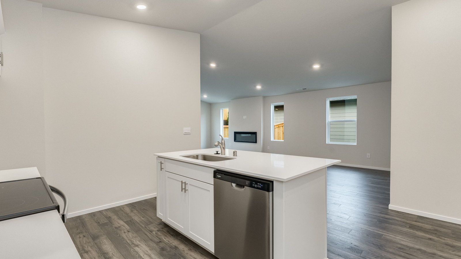 Kitchen with shaker cabinets, quartz counters, stainless steel appliances, pantry, and an island with a breakfast bar