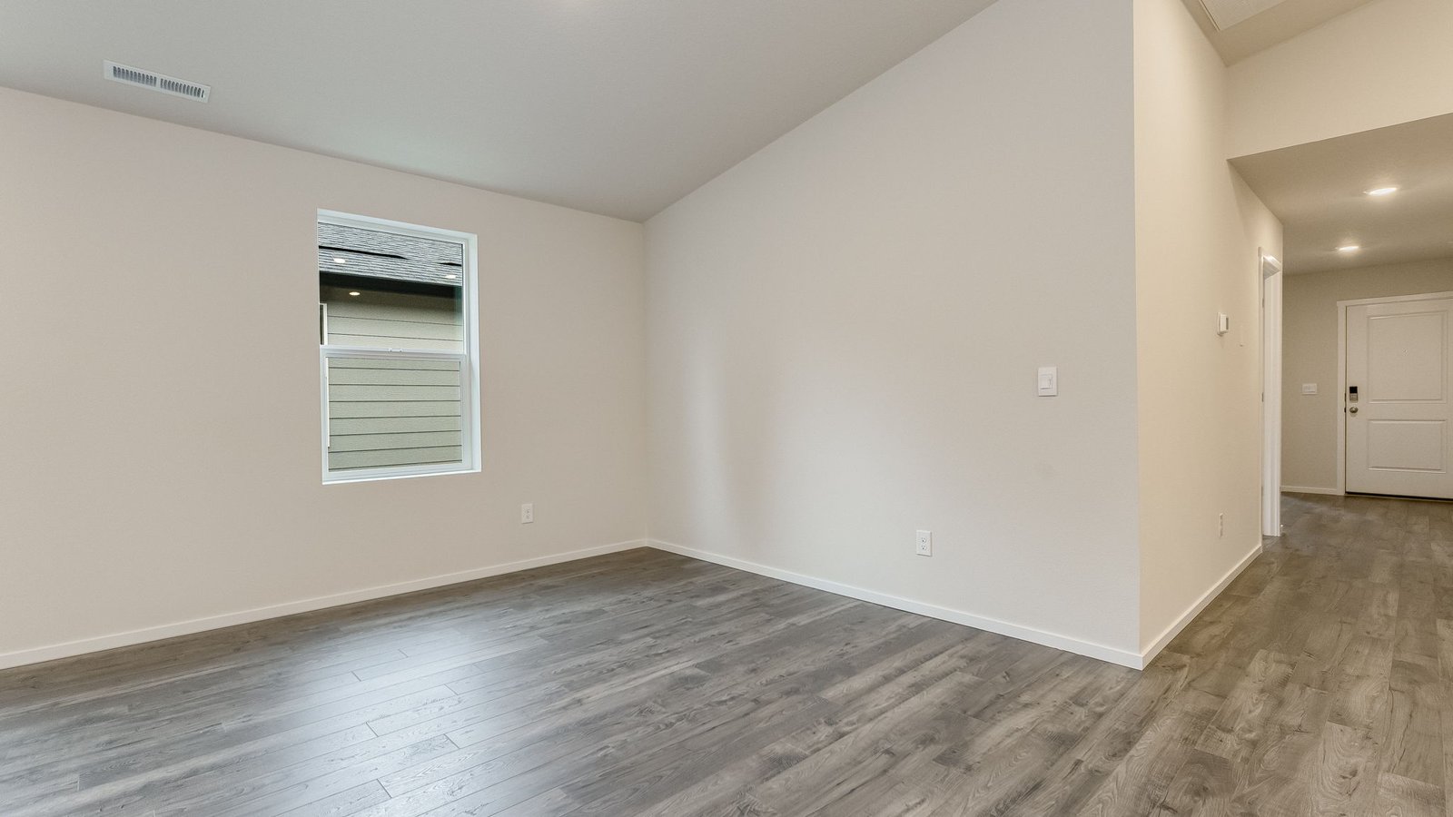 Great room with laminate flooring and an electric fireplace and vaulted ceilings