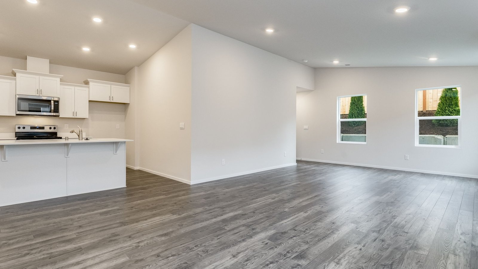 Great room with laminate flooring and an electric fireplace and vaulted ceilings