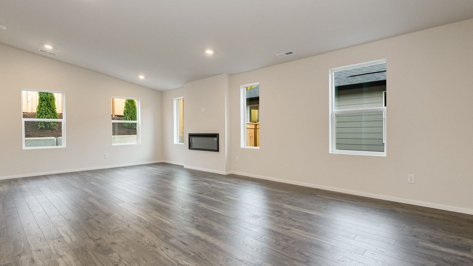 Great room with laminate flooring and an electric fireplace and vaulted ceilings