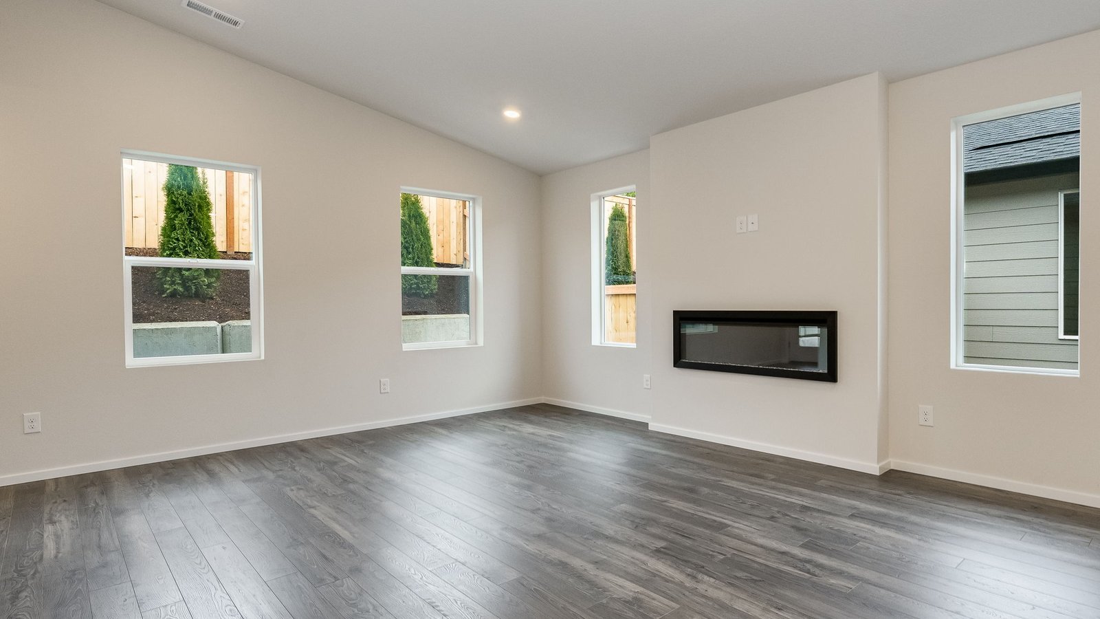 Great room with laminate flooring and an electric fireplace and vaulted ceilings