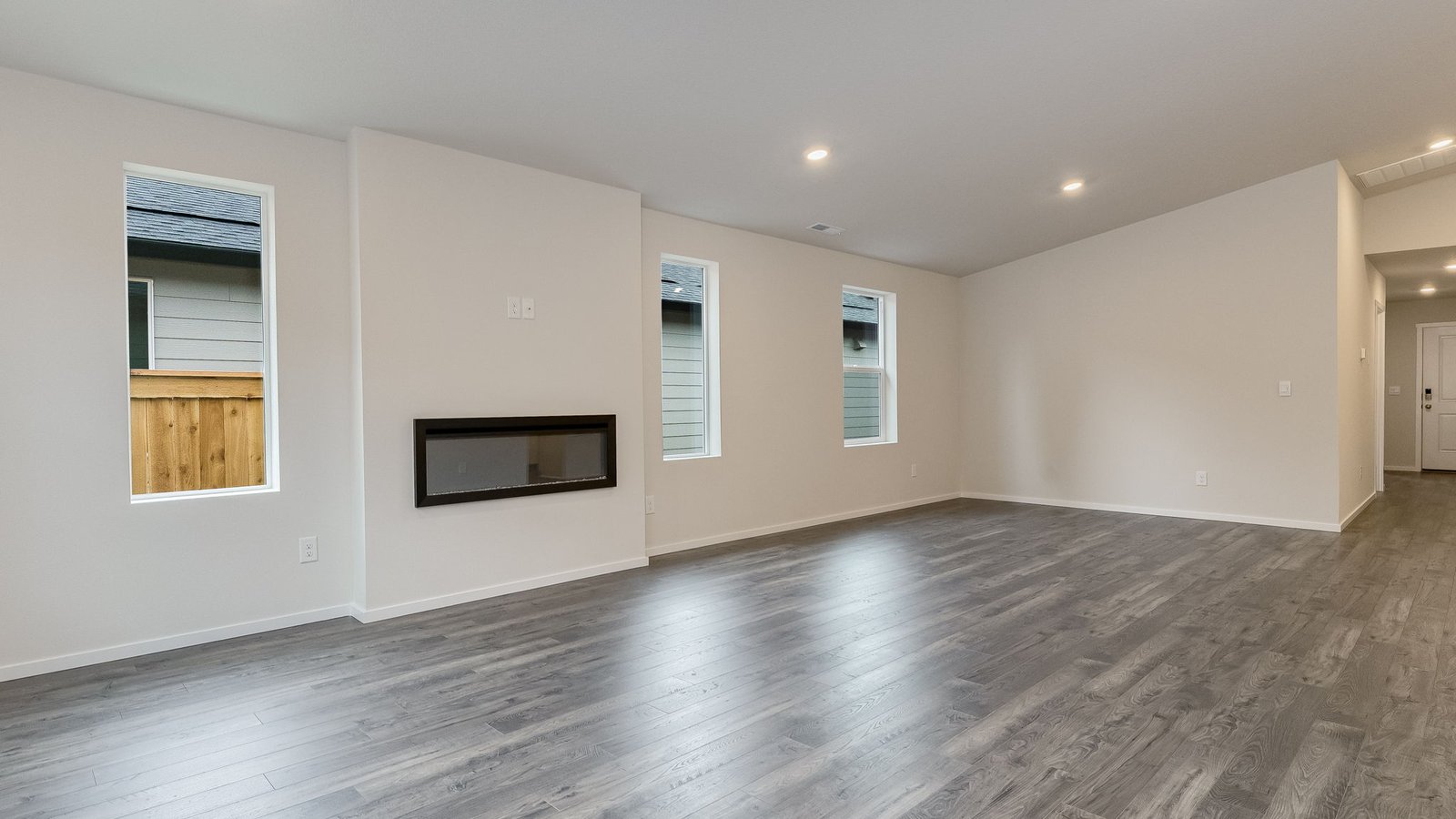 Great room with laminate flooring and an electric fireplace and vaulted ceilings