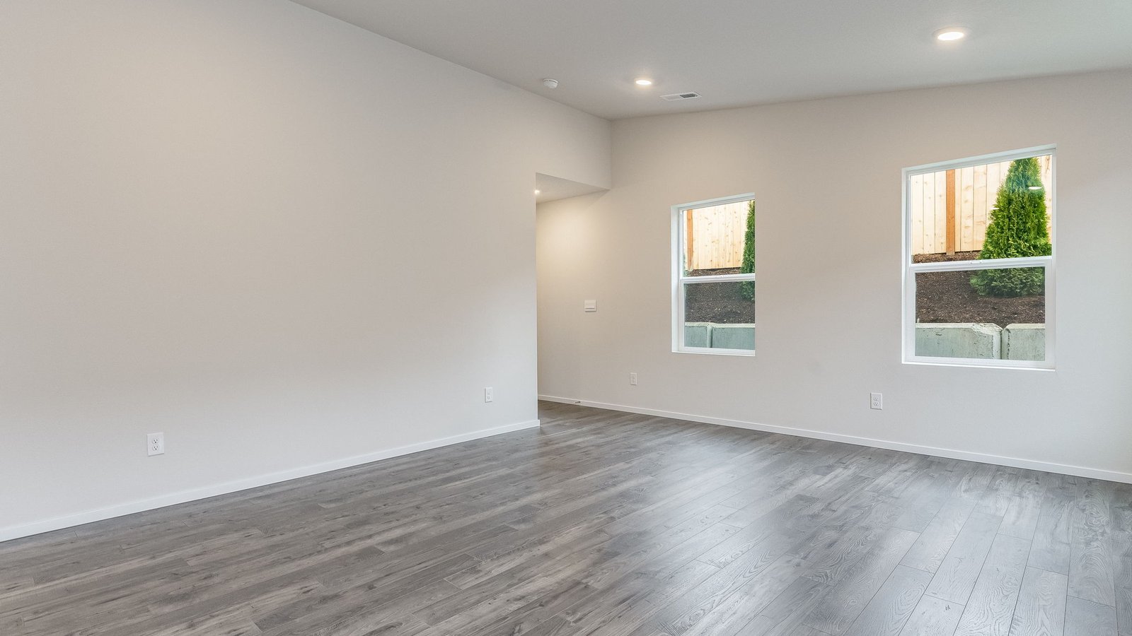 Great room with laminate flooring and an electric fireplace and vaulted ceilings