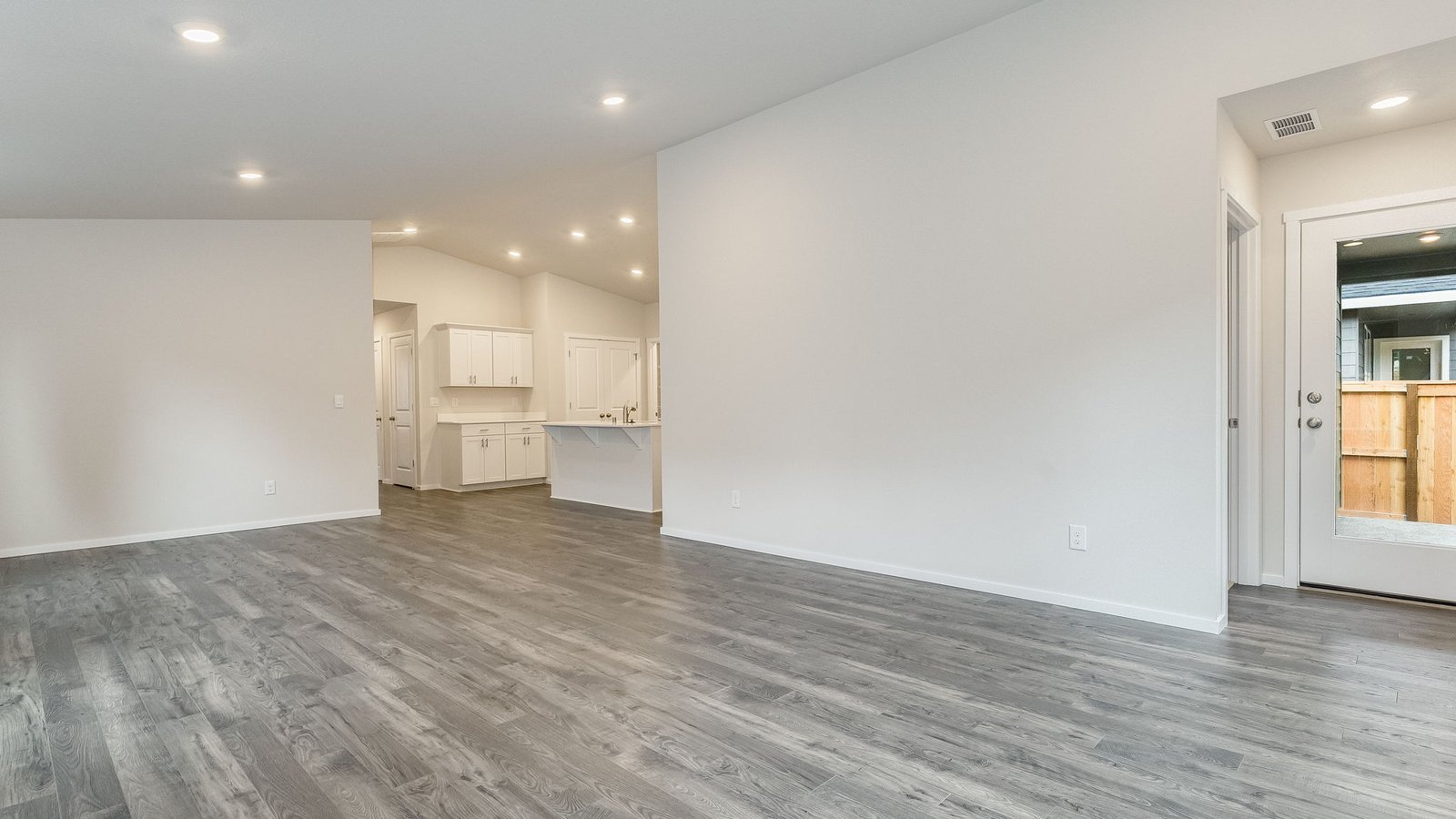 Great room with laminate flooring and an electric fireplace and vaulted ceilings