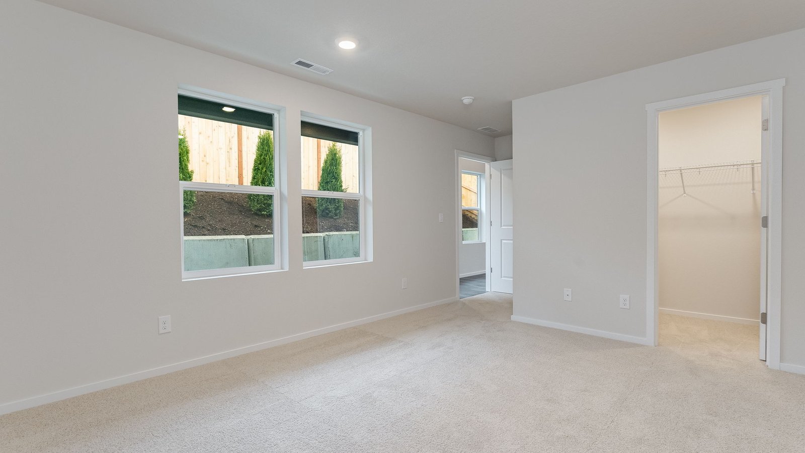 Primary bedroom with wall-to-wall carpet, a walk-in closet and an attached bathroom