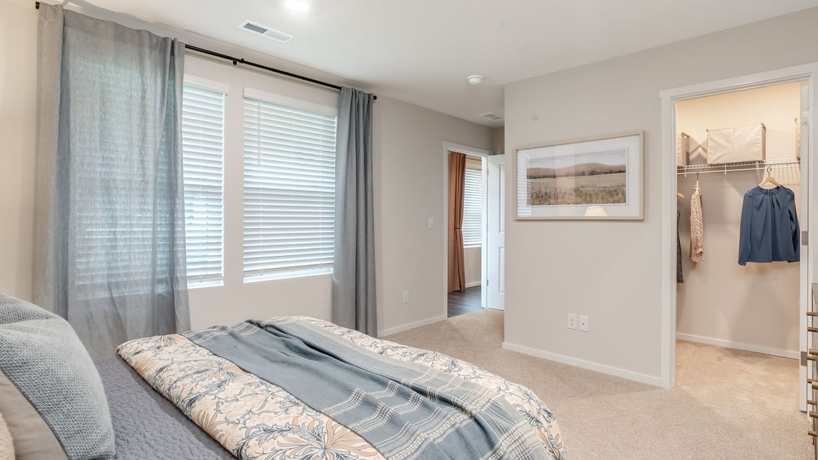 Primary bedroom with wall-to-wall carpet, a walk-in closet and an attached bathroom