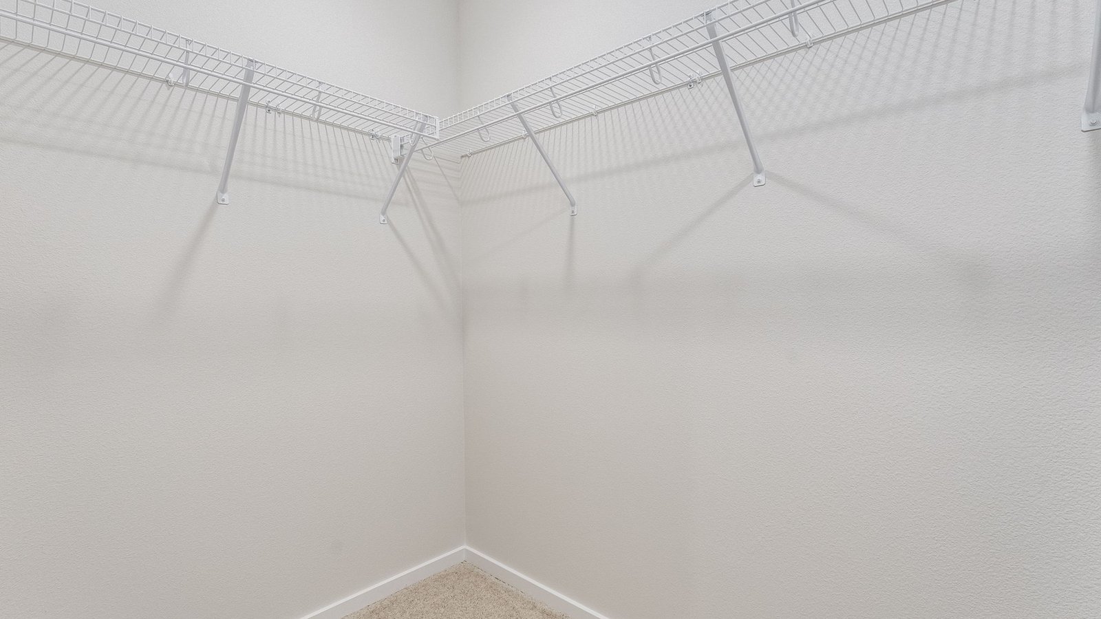 Primary bedroom walk-in closet with wire shelves