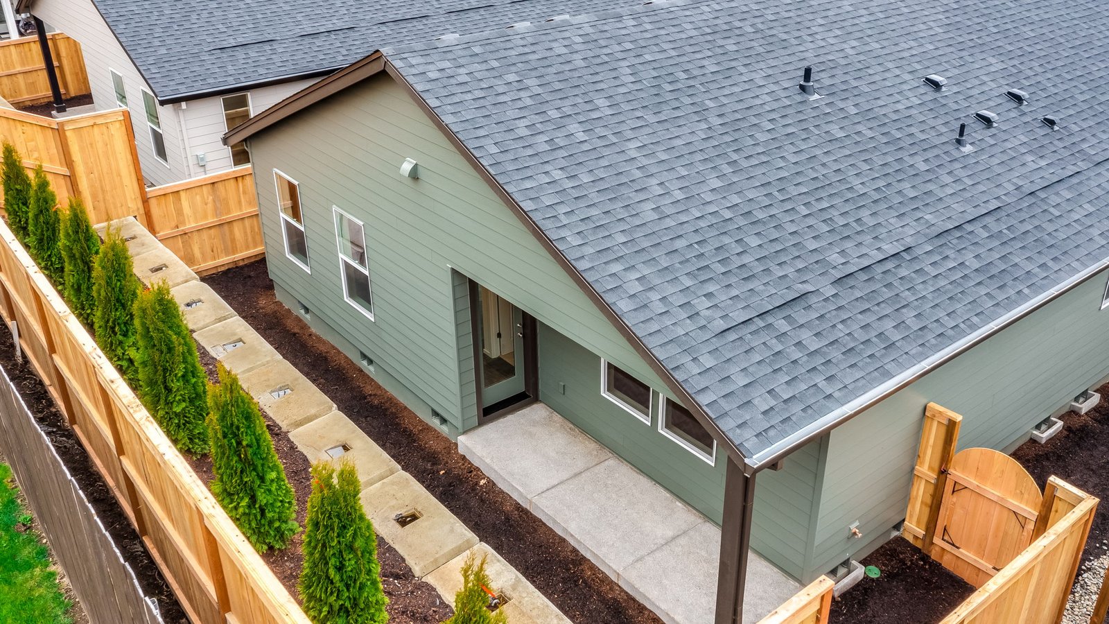 fully fenced backyard with sod lawn and a patio