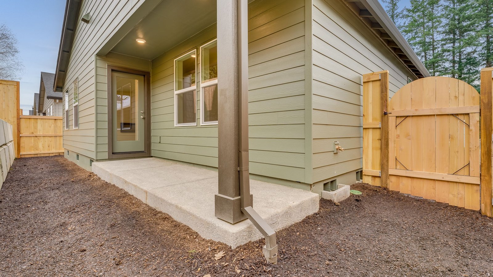 fully fenced backyard with sod lawn and a patio