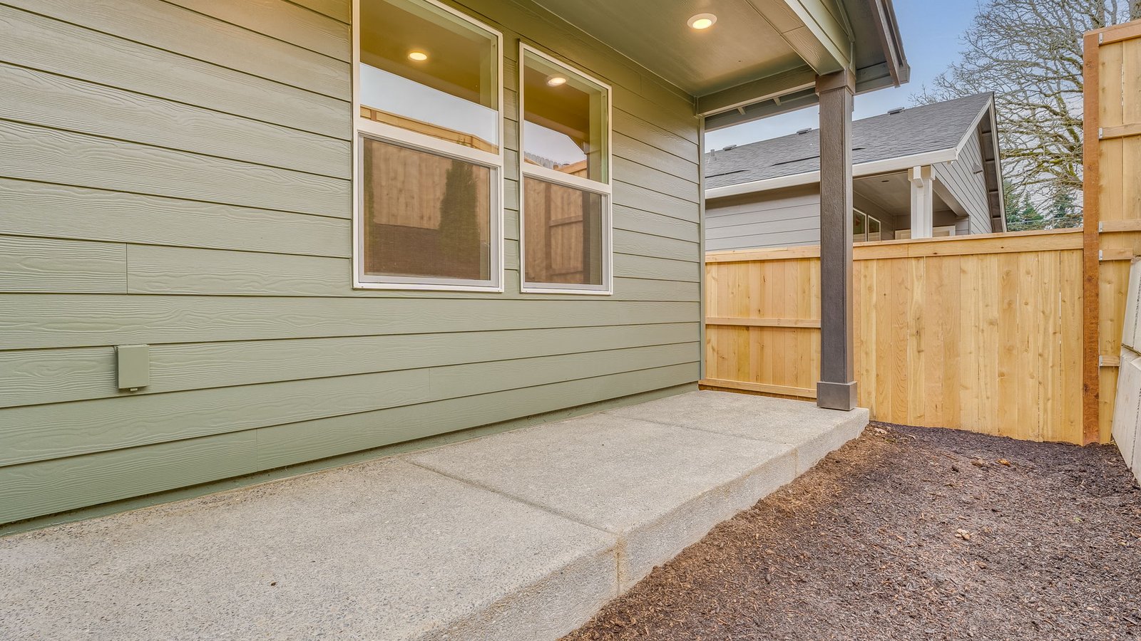 fully fenced backyard with sod lawn and a patio