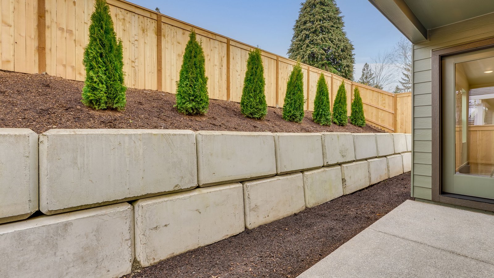 fully fenced backyard with sod lawn and a patio