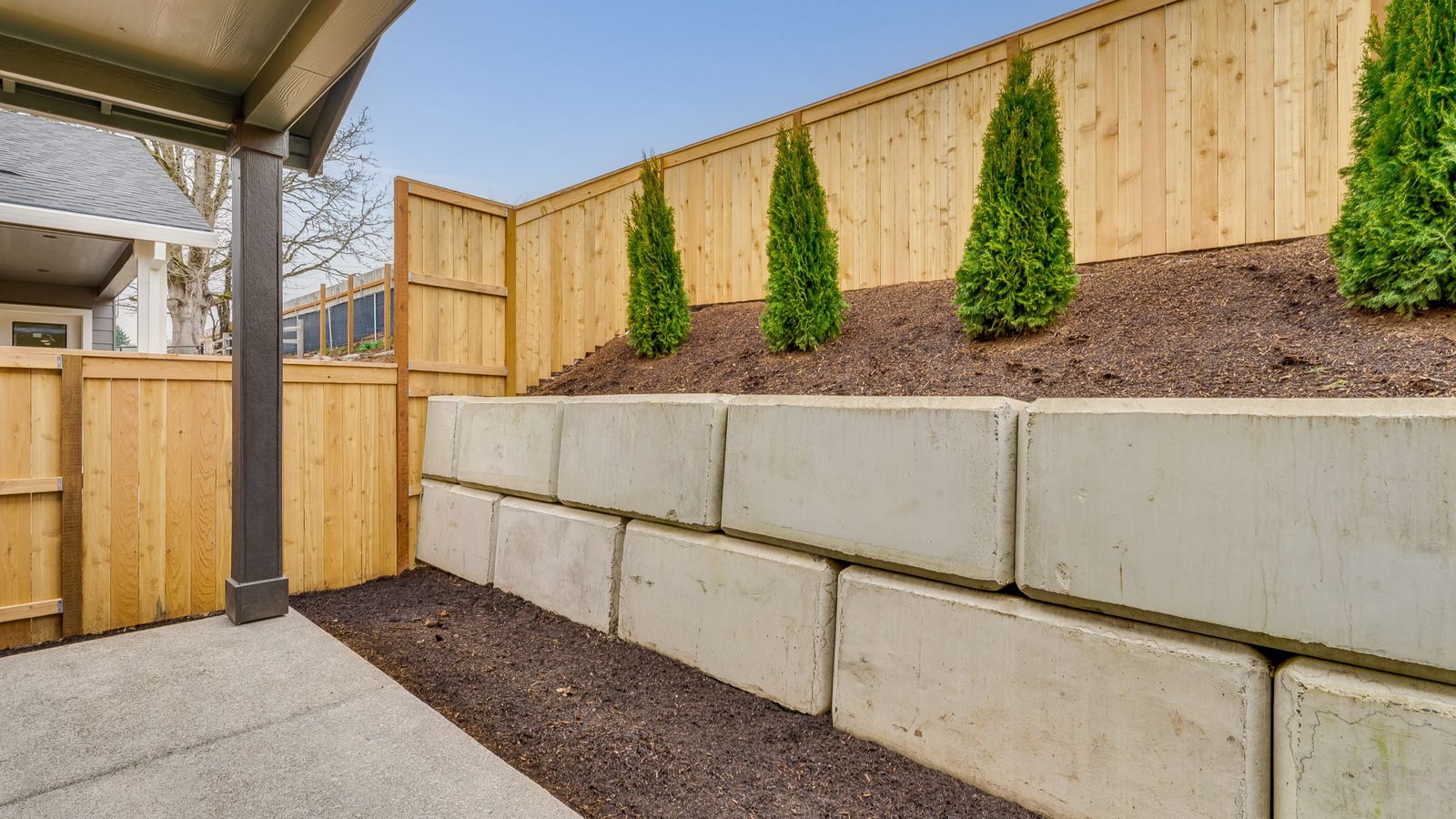 fully fenced backyard with sod lawn and a patio