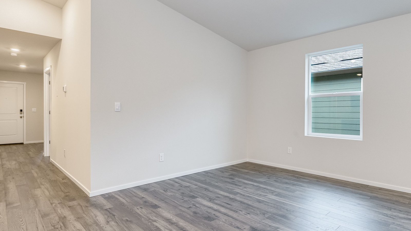 Great room with laminate flooring and an electric fireplace and vaulted ceilings