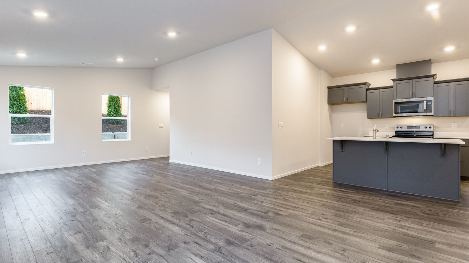 Great room with laminate flooring and an electric fireplace and vaulted ceilings