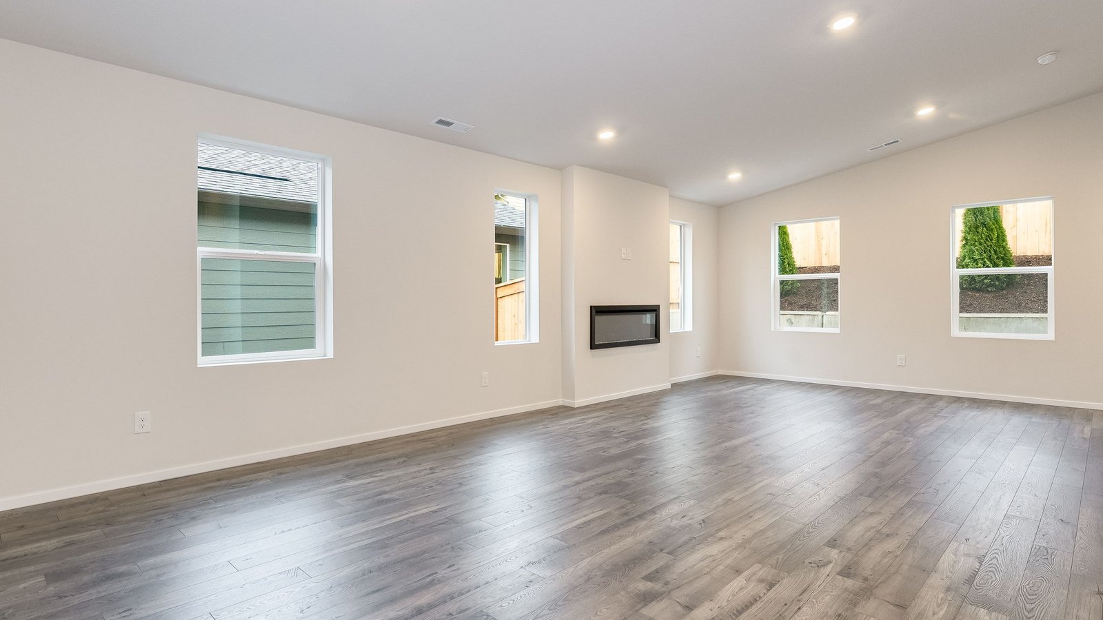 Great room with laminate flooring and an electric fireplace and vaulted ceilings