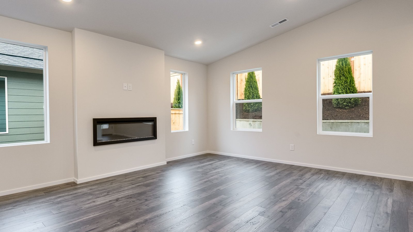 Great room with laminate flooring and an electric fireplace and vaulted ceilings