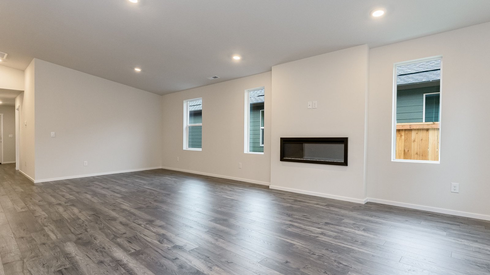 Great room with laminate flooring and an electric fireplace and vaulted ceilings