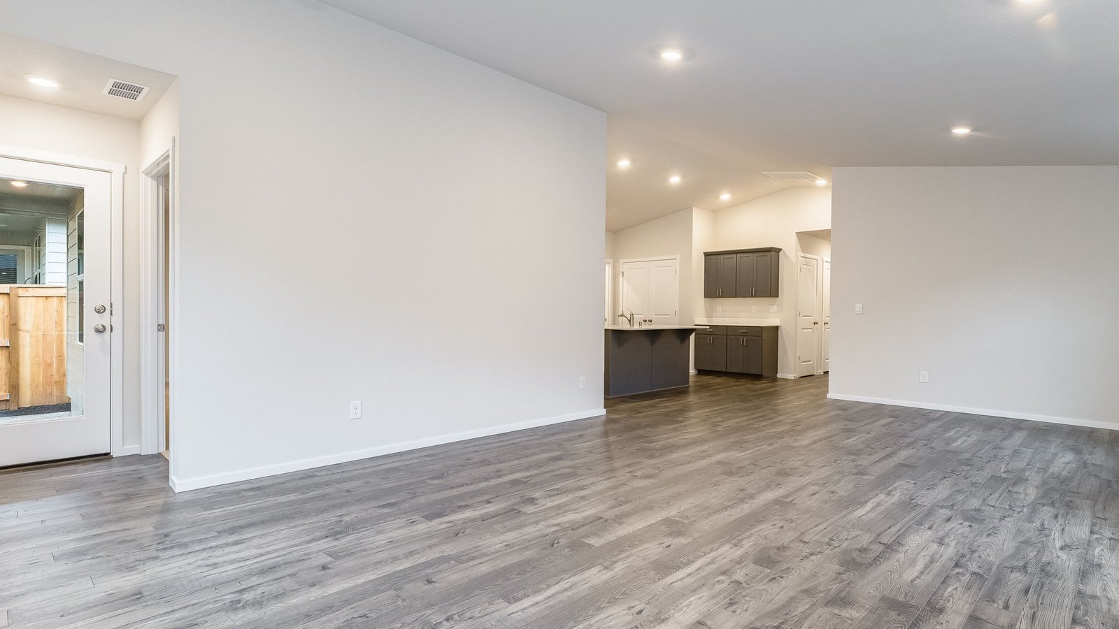 Great room with laminate flooring and an electric fireplace and vaulted ceilings