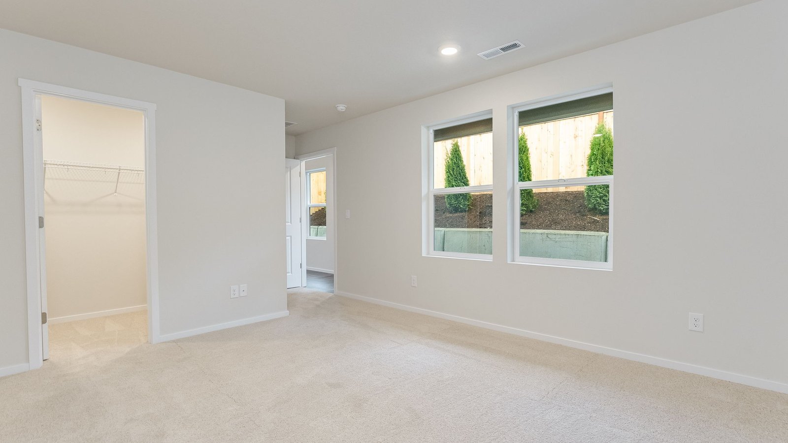 Primary bedroom with wall-to-wall carpet, a walk-in closet and an attached bathroom