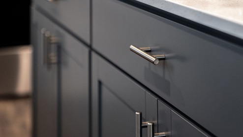 Gray shaker-style kitchen and bathroom cabinets with chrome hardware