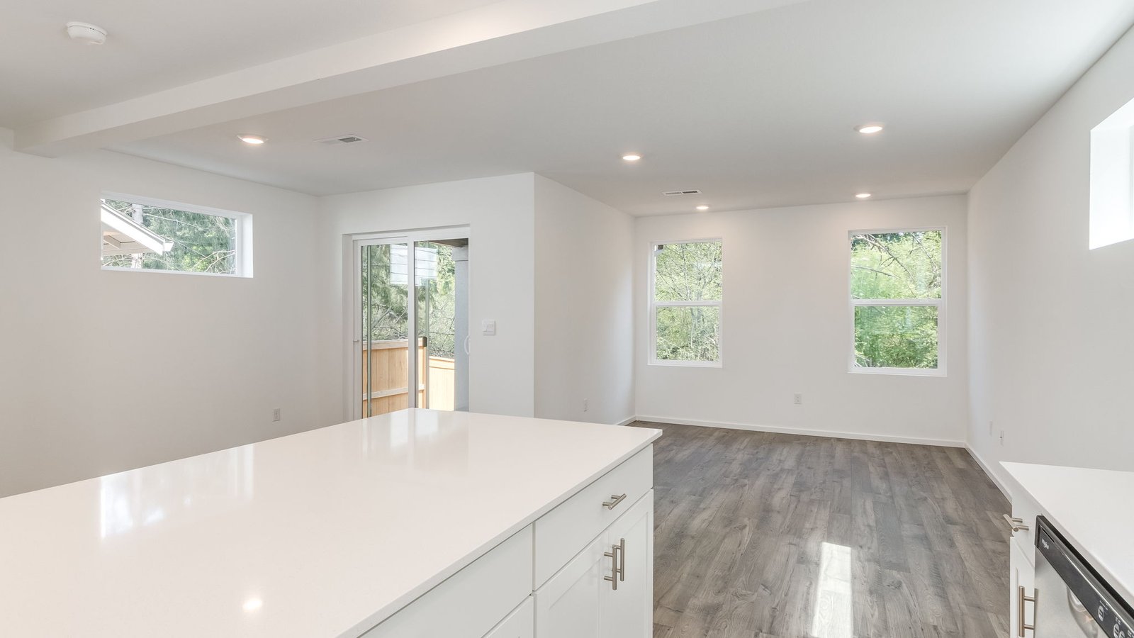 Kitchen with shaker cabinets, quartz counters, stainless steel appliances, pantry, and an island with a breakfast bar