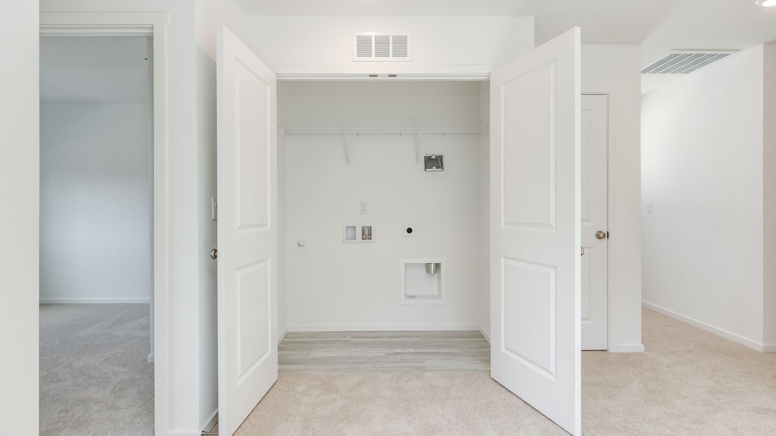 Laundry closet with wire shelves and washer and dryer hookups