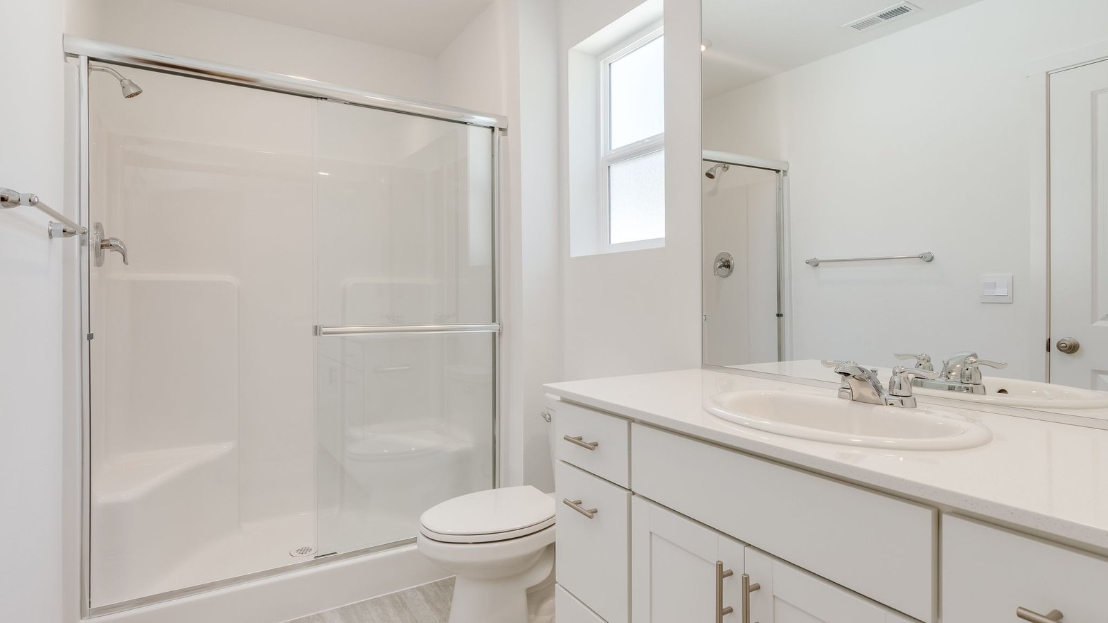Primary bathroom with quartz counters and a walk-in shower