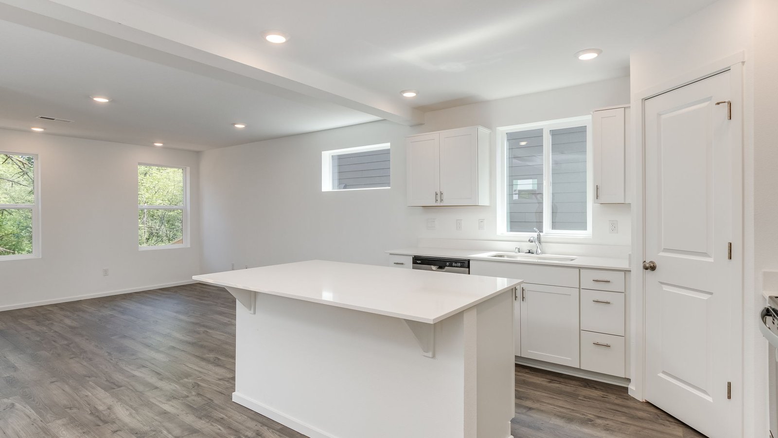 Kitchen with shaker cabinets, quartz counters, stainless steel appliances, pantry, and an island with a breakfast bar
