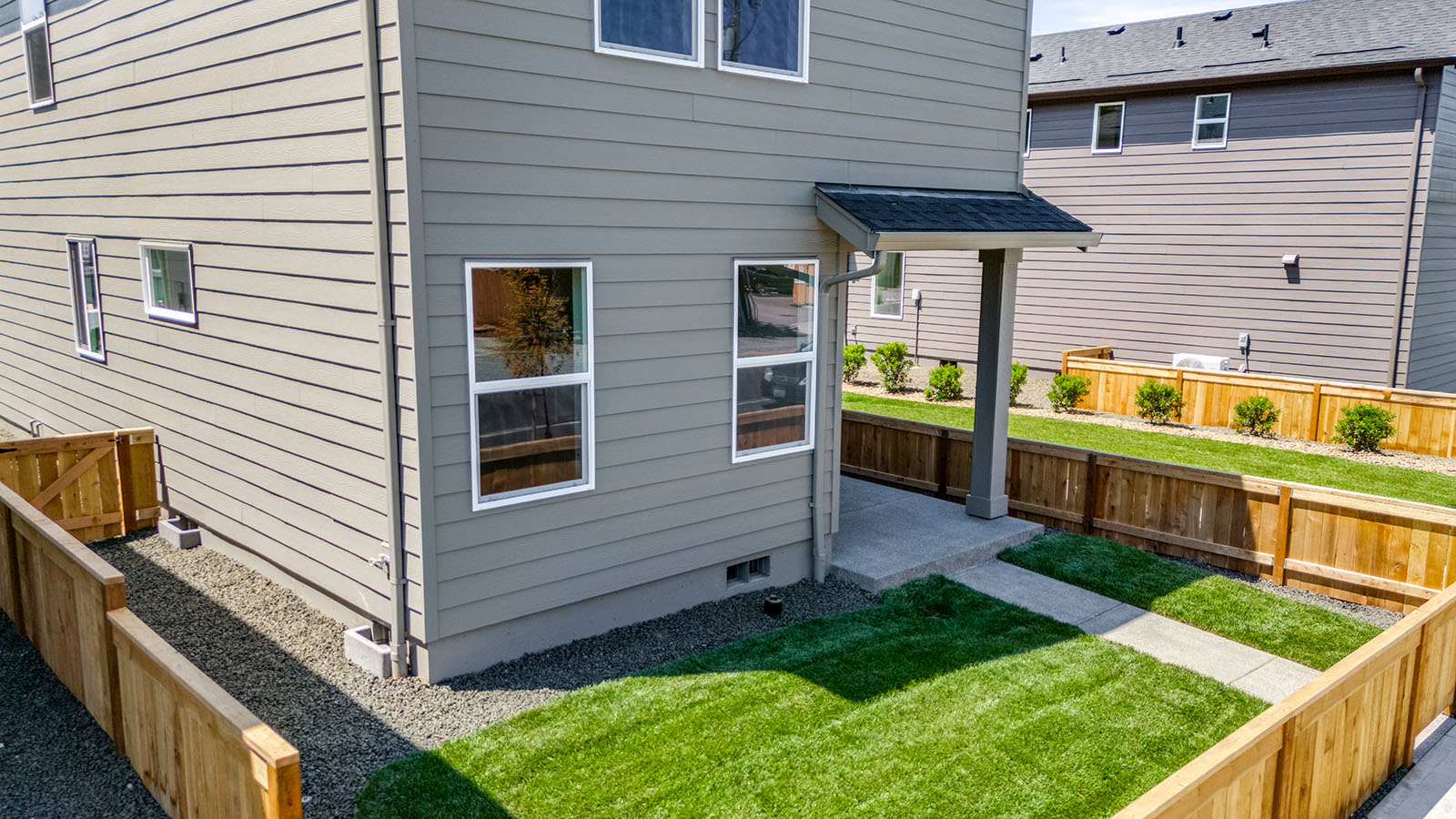 fully fenced backyard with sod lawn and a patio