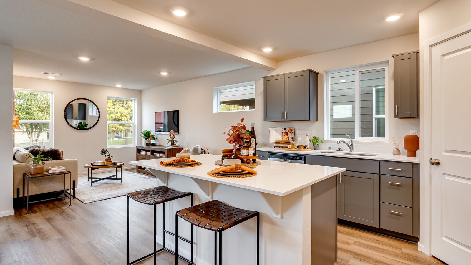 Kitchen with shaker cabinets, quartz counters, stainless steel appliances, pantry, and an island with a breakfast bar