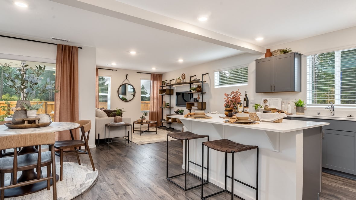 Kitchen with shaker cabinets, quartz counters, stainless steel appliances, pantry, and an island with a breakfast bar