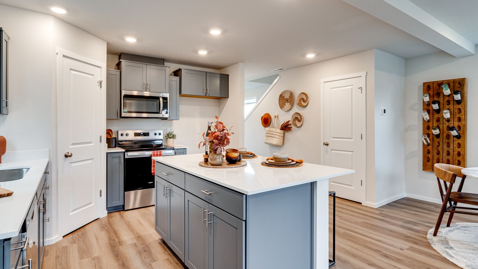 Kitchen with shaker cabinets, quartz counters, stainless steel appliances, pantry, and an island with a breakfast bar
