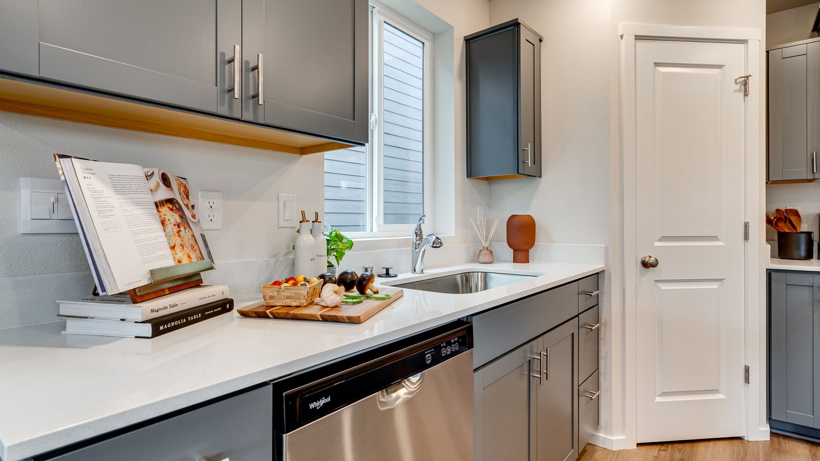 Kitchen with shaker cabinets, quartz counters, stainless steel appliances, pantry, and an island with a breakfast bar